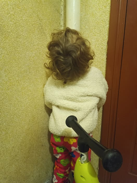 A child is kissing the warm pipe